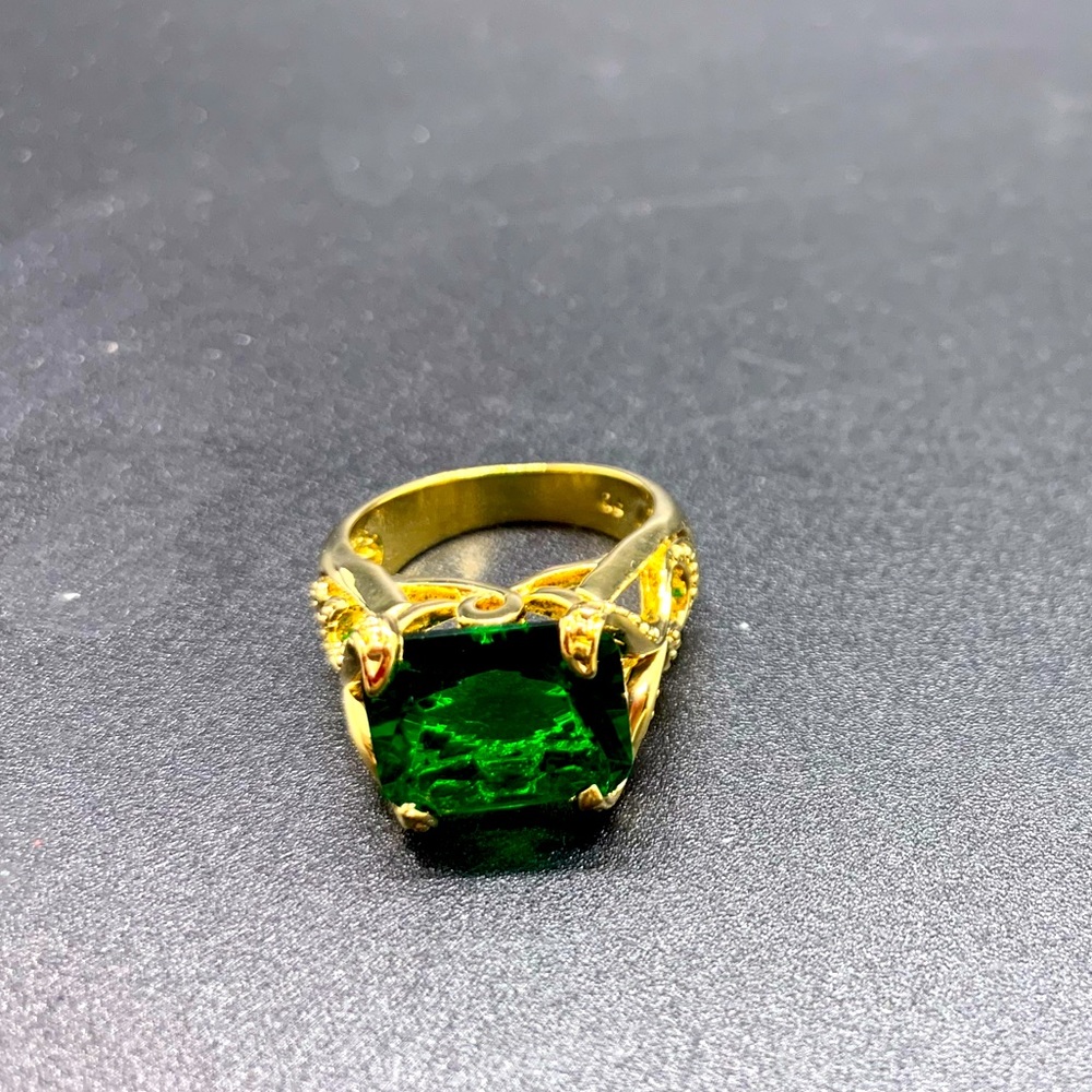 Ornate Gold Colored ring with emerald style gem
